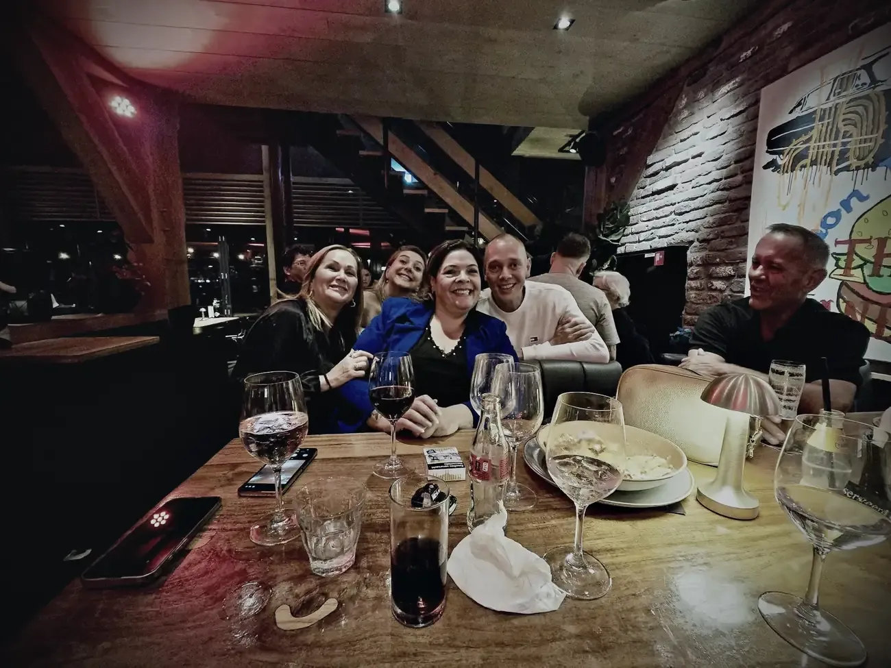 Aan tafel op het afscheidsfeestje, met glazen en lachende gezichten