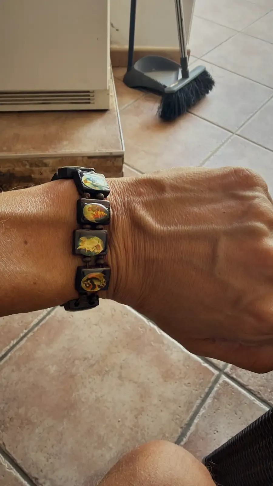 Het armbandje om mijn pols, met kleine afbeeldingen erop