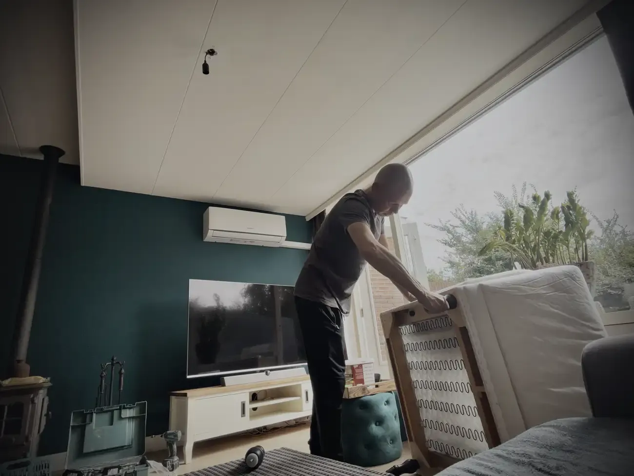 Wesley kantelt de bank in de woonkamer om hem uit elkaar te halen
