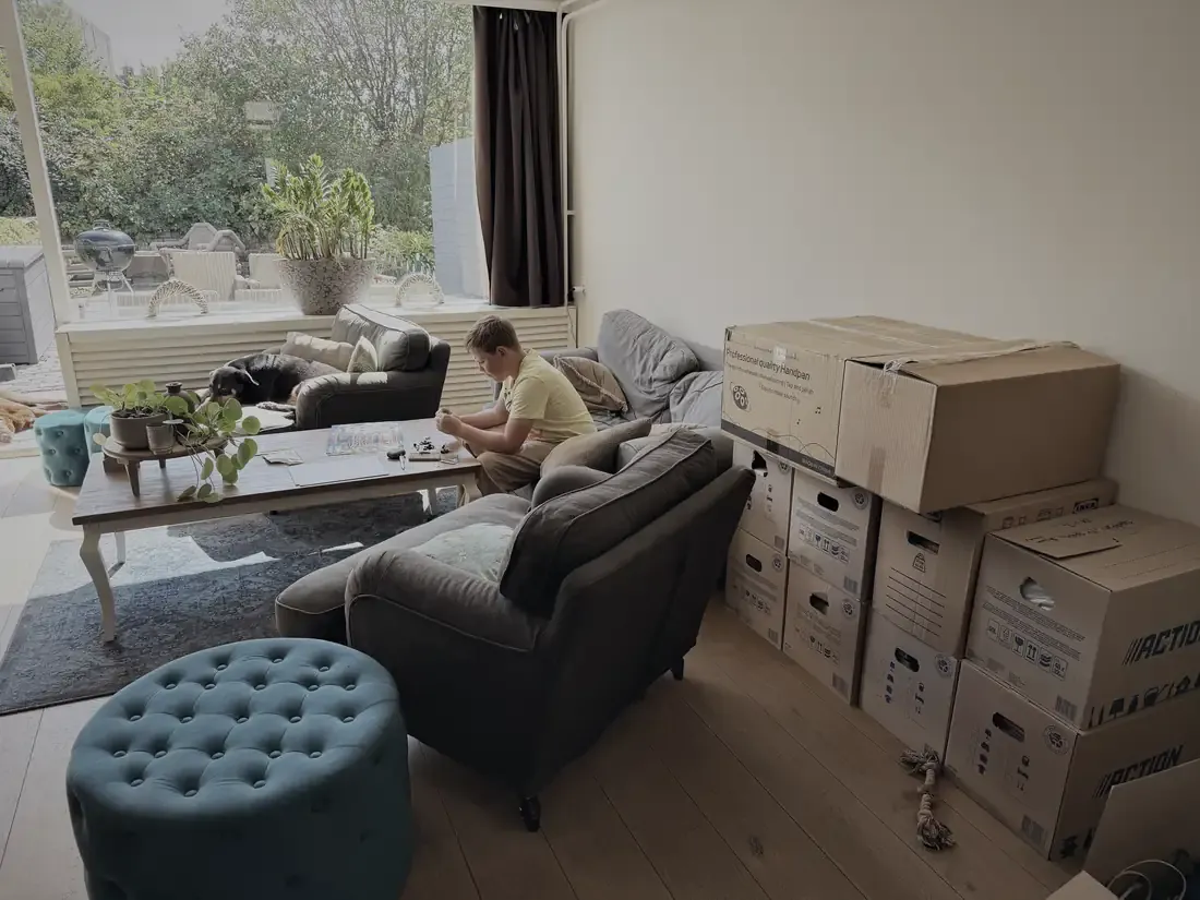 Bas op de bank, druk met LEGO tussen de verhuisdozen