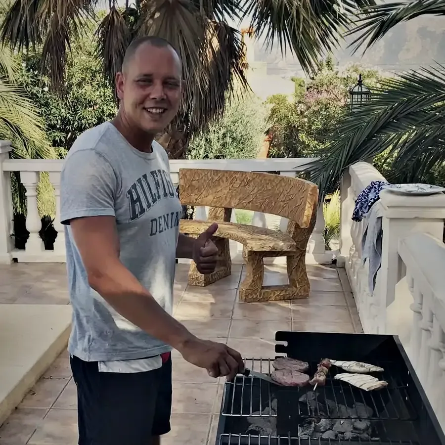 Wesley aan de barbecue op een terras in Alfaz del Pi