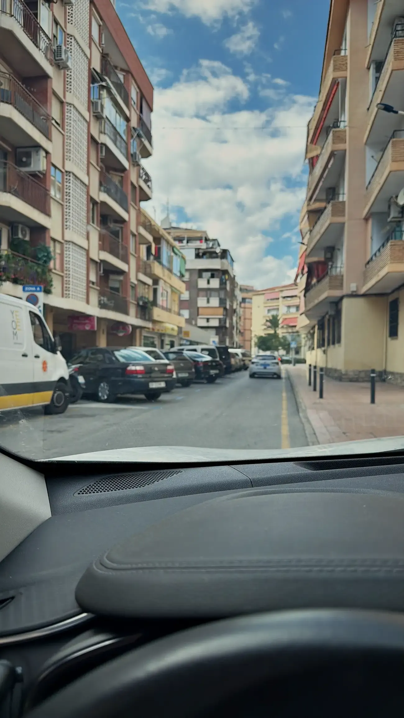 Vanachter het stuur in het centrum van Benidorm, hoogbouw aan weerszijden van de weg