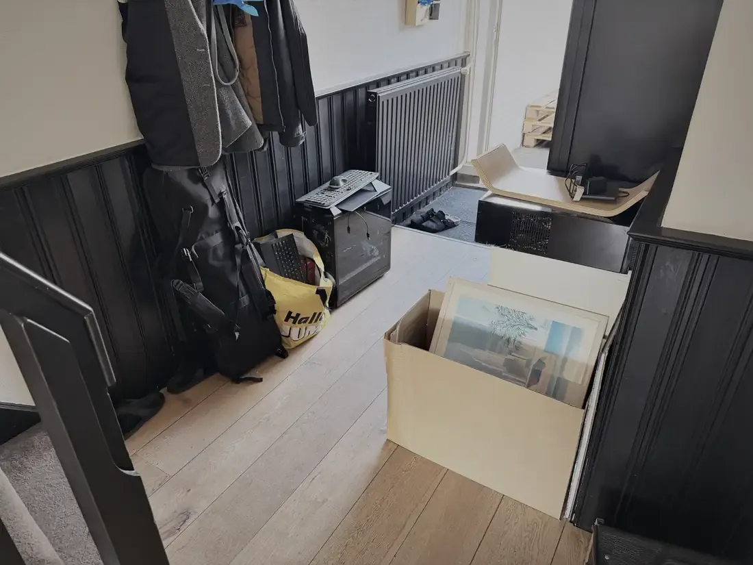 De gang vol tassen en een doos schilderijen voor Jeff