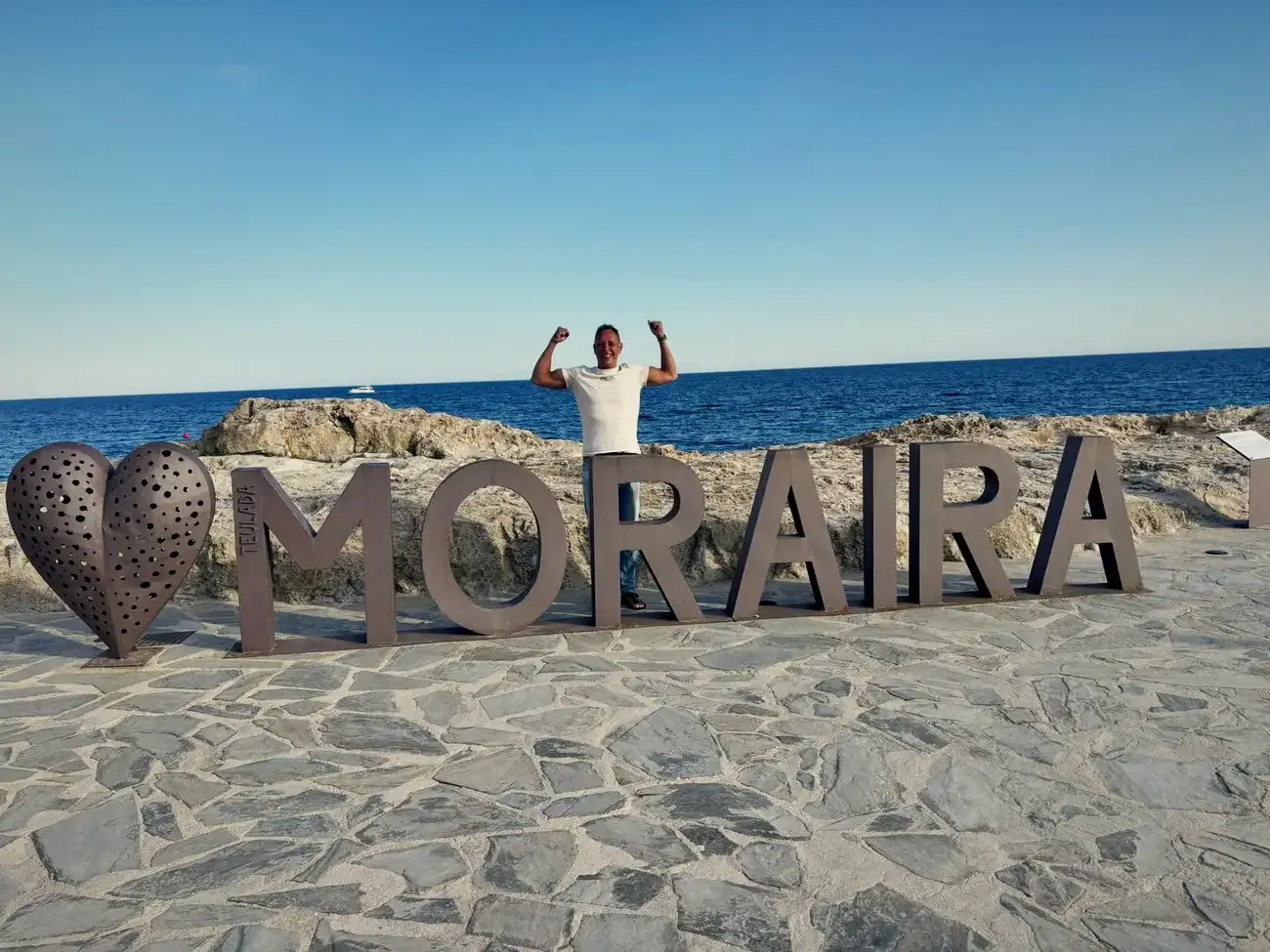 Wesley juichend bij de letters van Moraira aan zee
