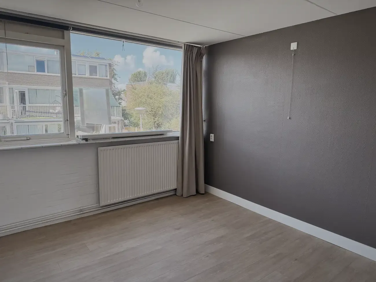 Een lege slaapkamer met een bruine wand
