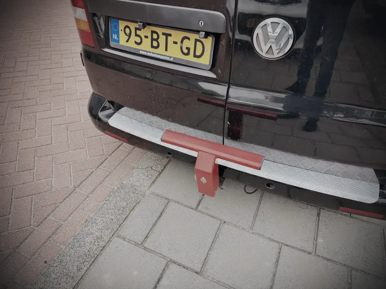 Het rode slot op de trekhaak, achter op de bus
