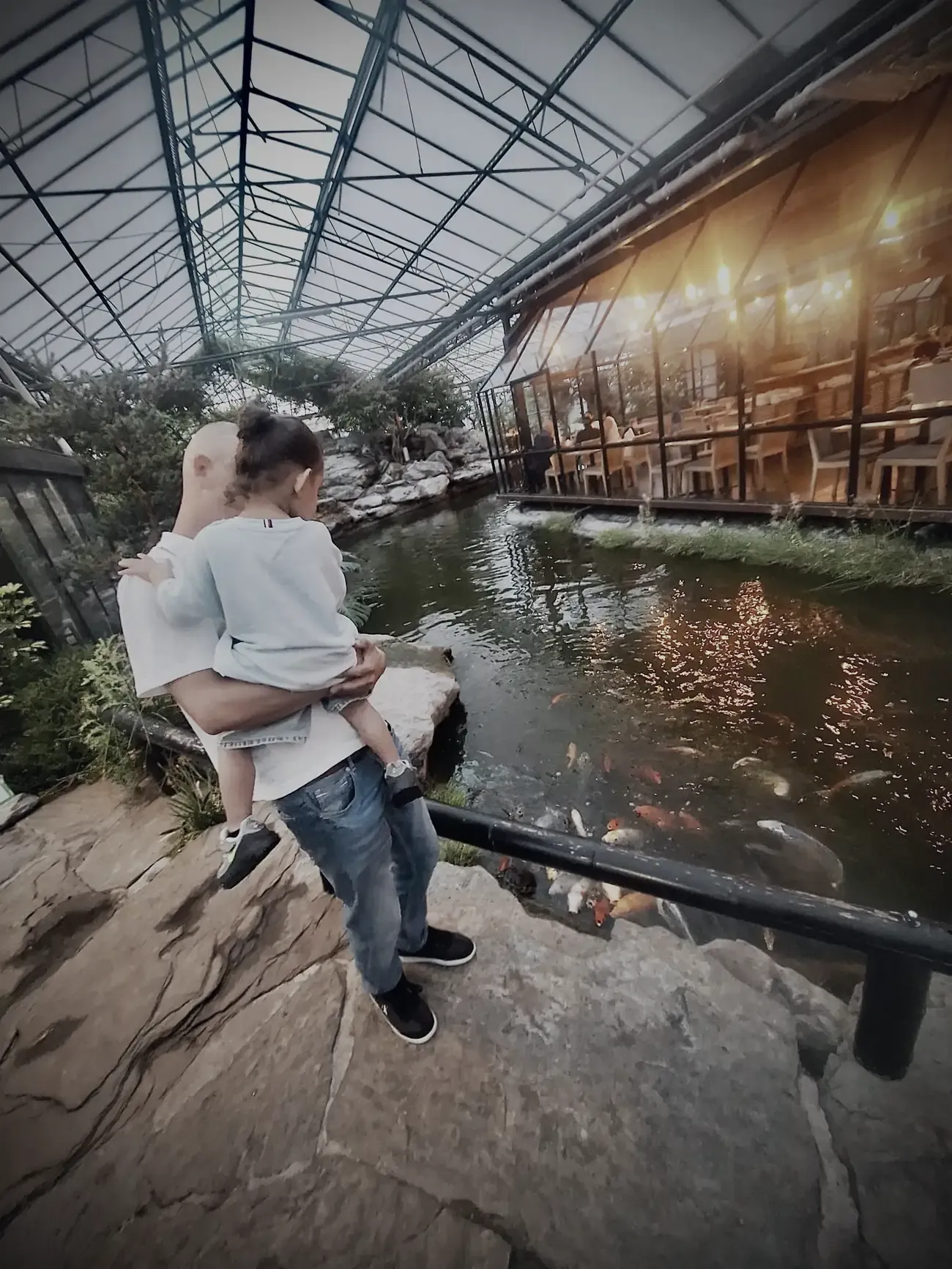 Wesley met het kleintje op de arm aan de rand van de koivijver