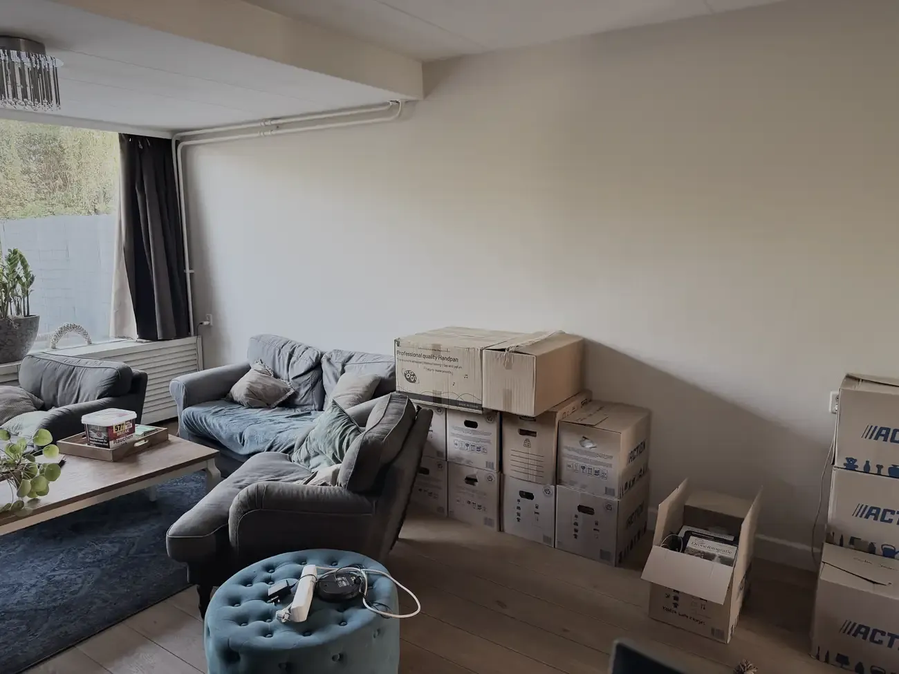 De woonkamer vol dozen en spullen